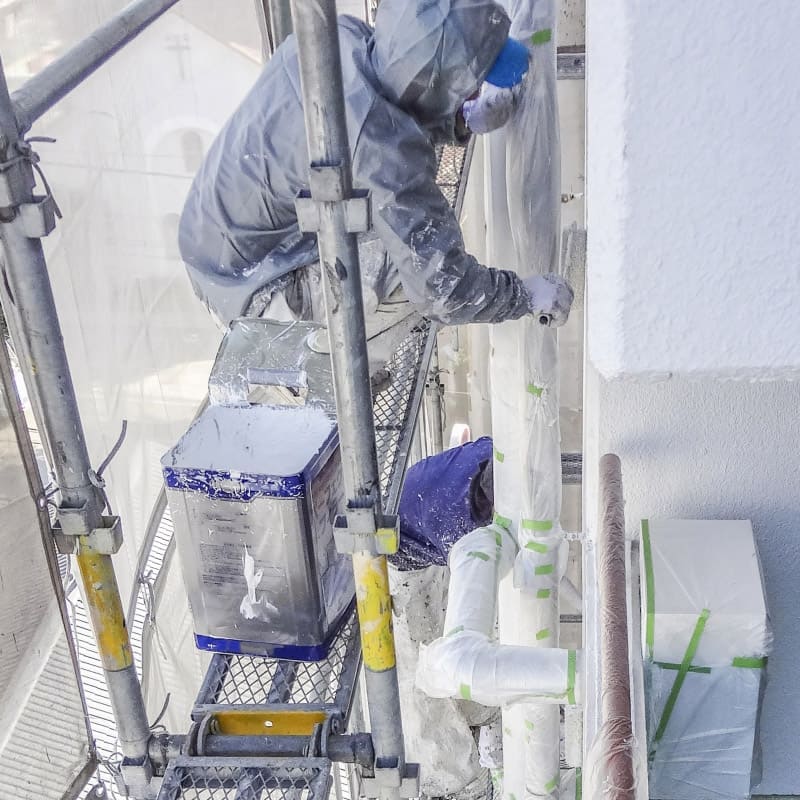 壁を塗装する男性