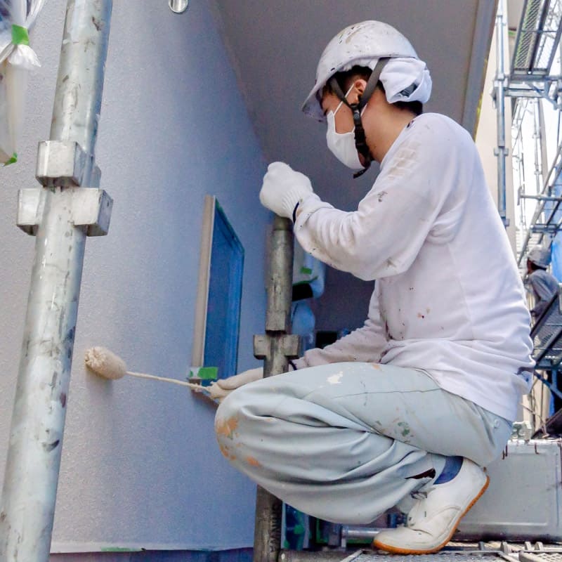 壁を塗装する男性